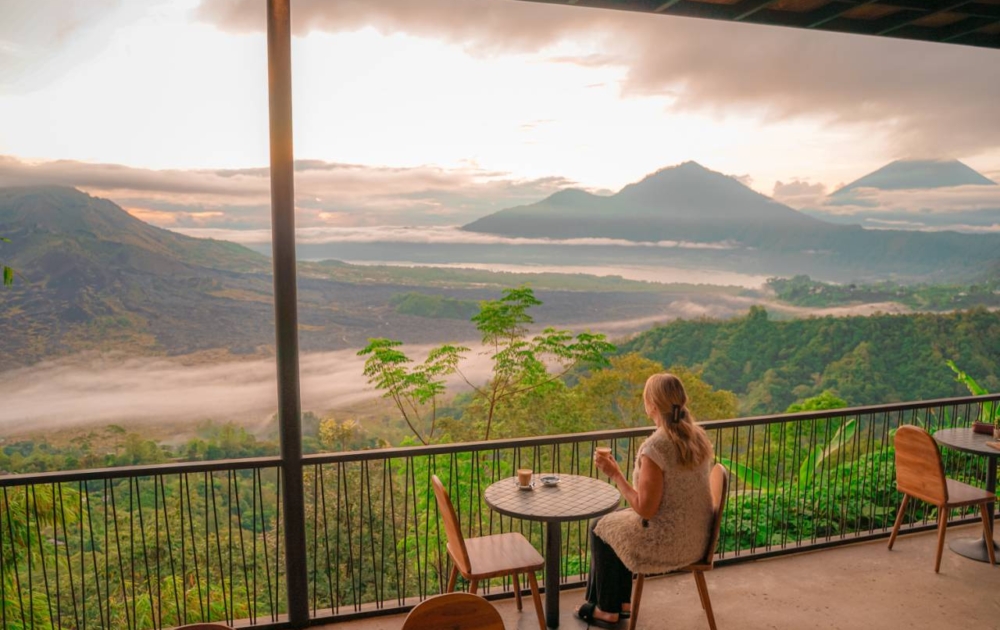 Girl drinking coffee with a view of Mt Batur Volcano Bali