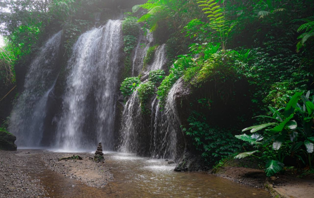 Peaceful Waterfall surrounded by lush green jungle near Ubud Bali
