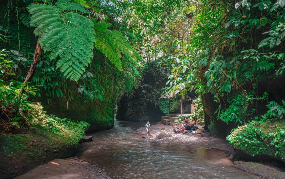 Family relaxing near river and waterfall in Ubud Bali