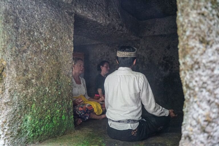 Two females following a guided Balinese mediation inside ancient cave near Ubud Bali