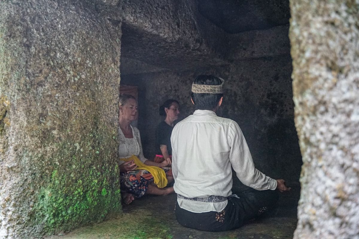 Two females following a guided Balinese mediation inside ancient cave near Ubud Bali